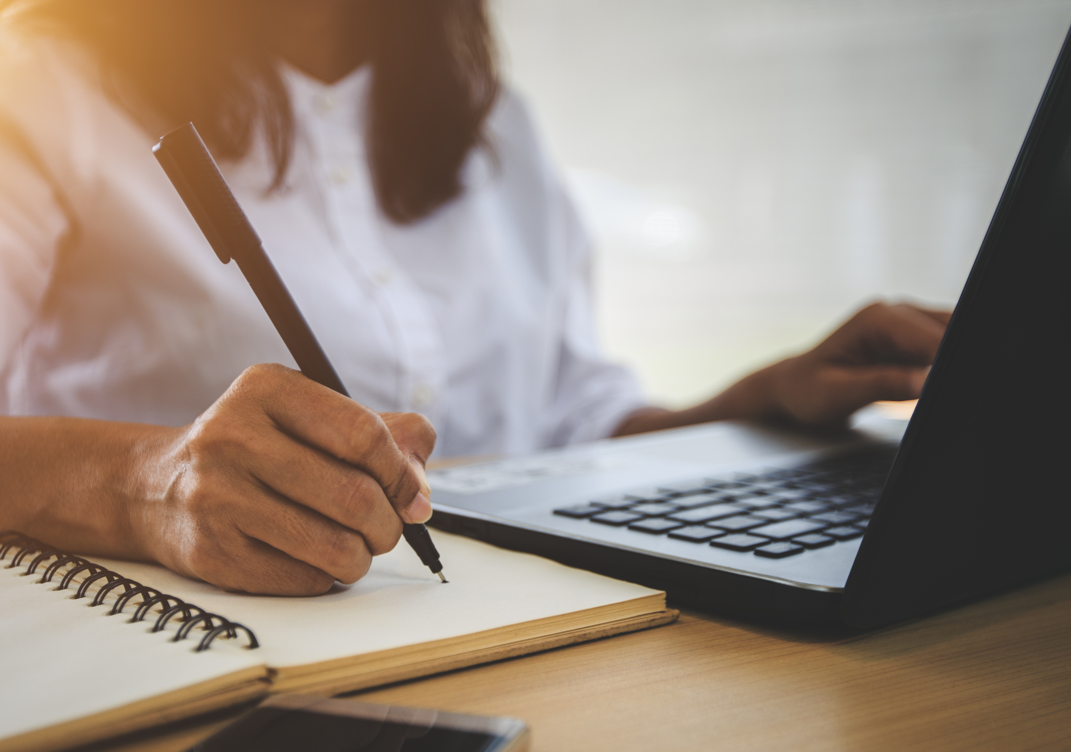 Female hand taking notes at desk