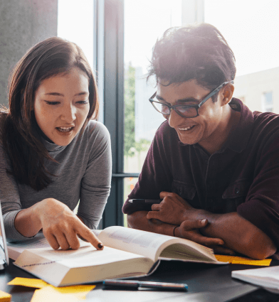 Male and female students working with textbook